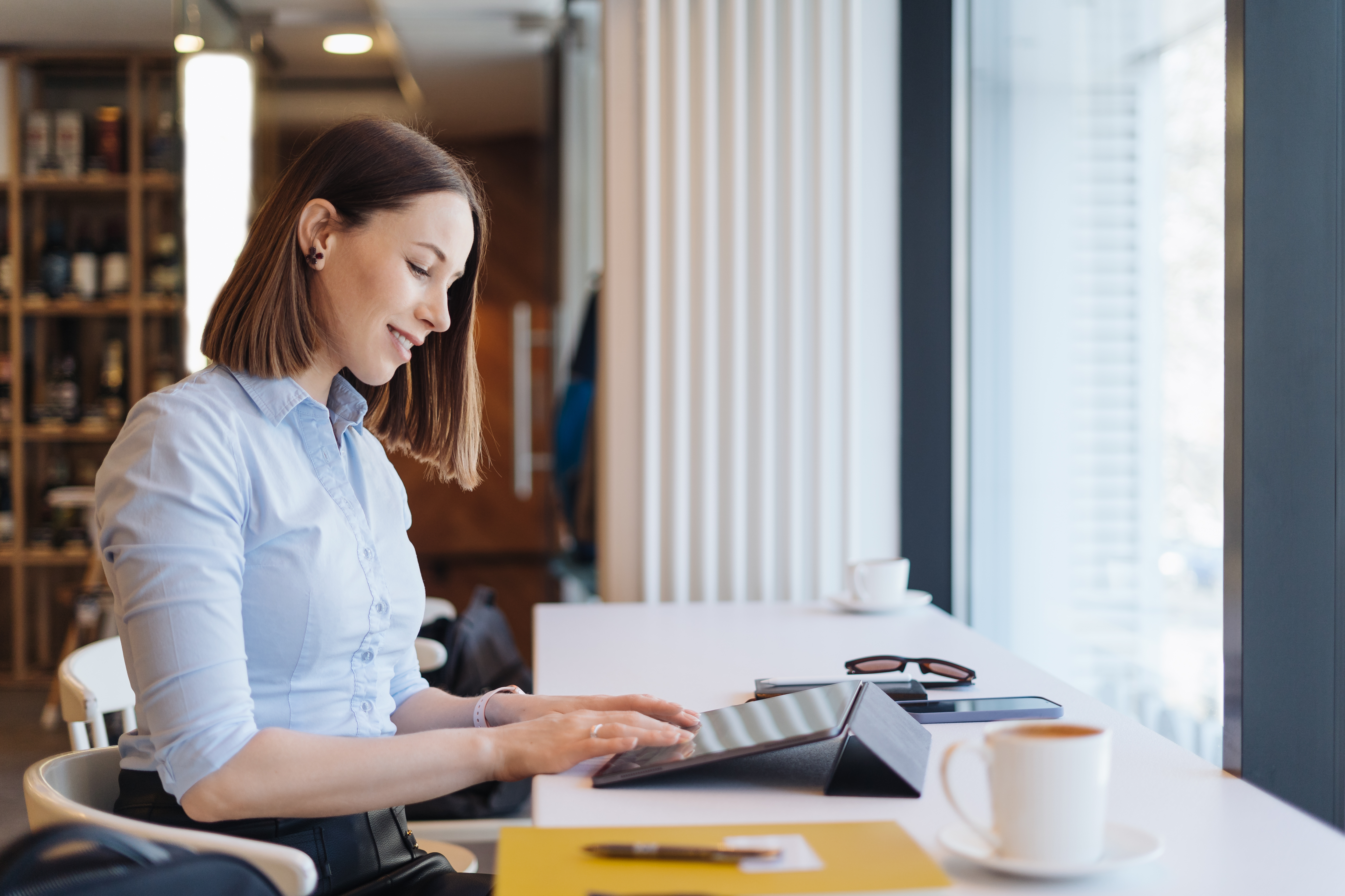 attractive-female-with-cute-smile-having-coffee-while-relaxin-break-with-digital-tablet.jpg