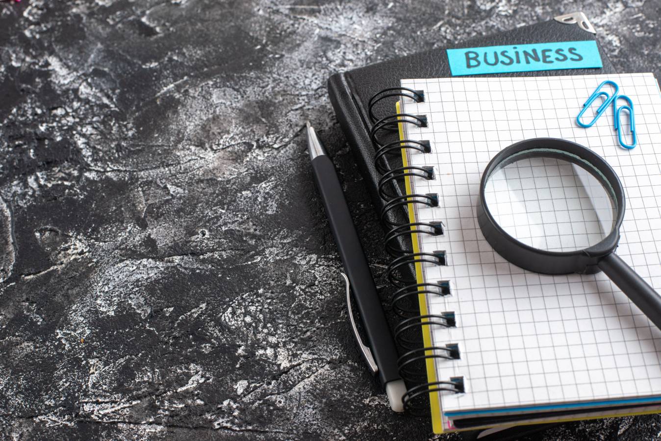 front-view-business-note-with-notepads-magnifier-dark-background.jpg