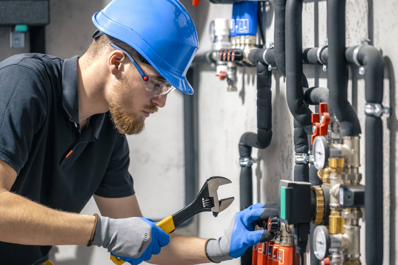 man-installs-heating-system-house-checks-pipes-with-wrench.jpg