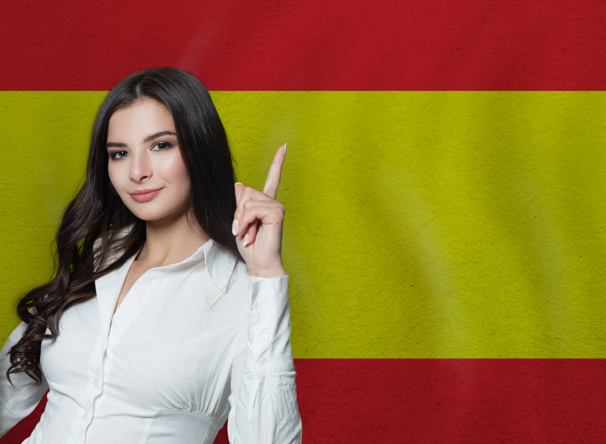 woman-pointing-up-spanish-flag-background-education-business-concept.jpg